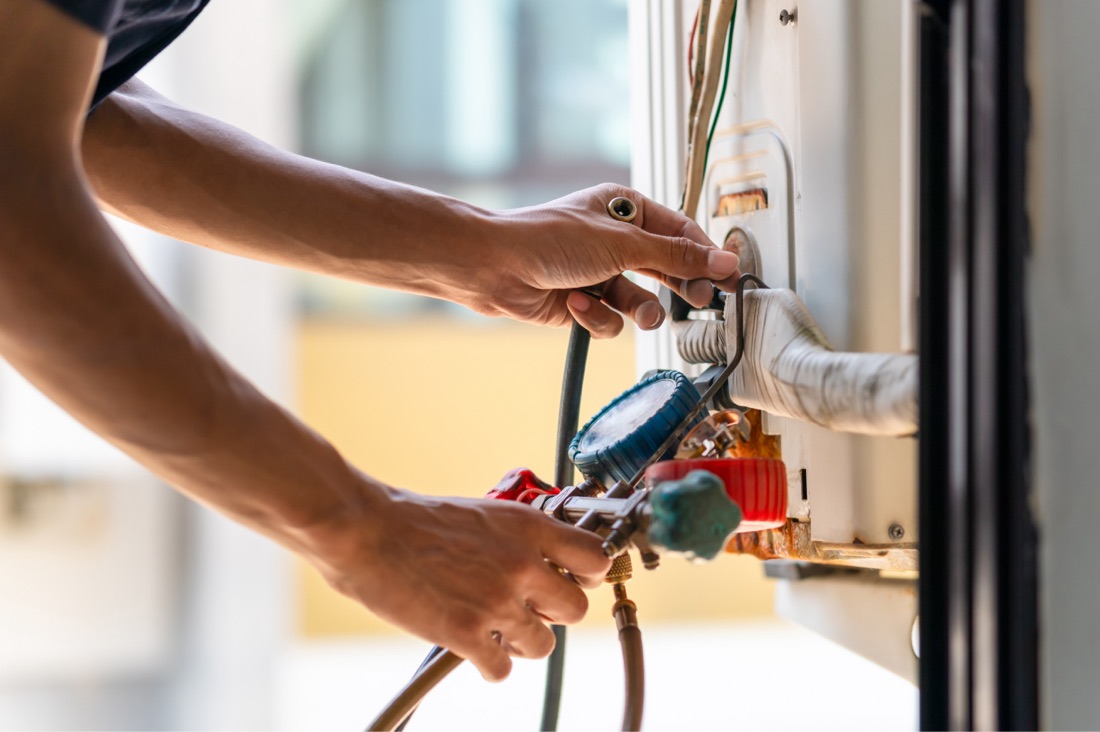Hands of a technician diagnosing an HVAC systems
