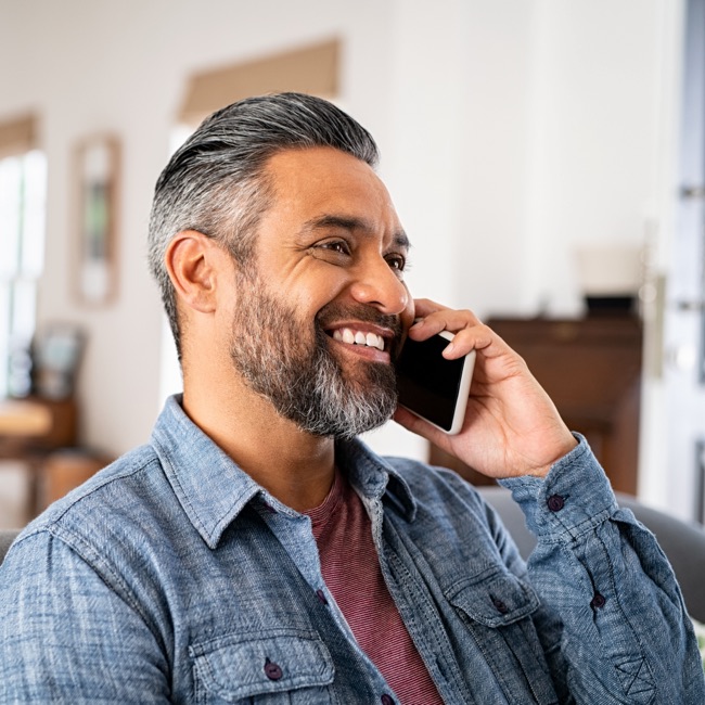 Man smiling while on the phone
